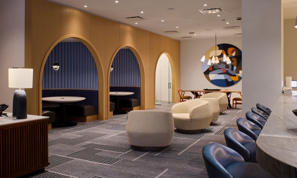Modern resident lounge with private seating booths, comfortable chairs, and contemporary wood finishes.