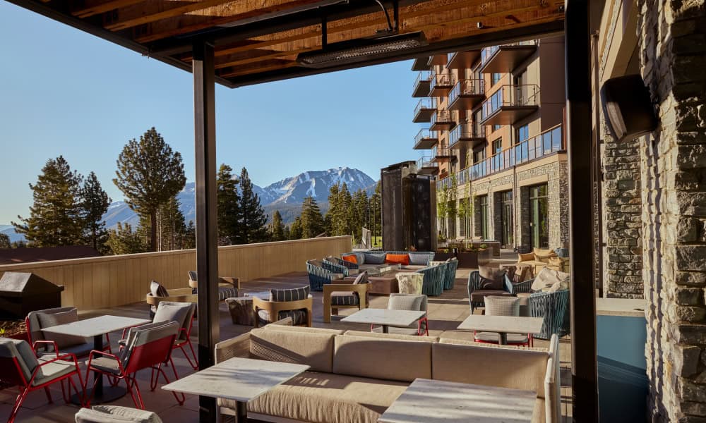 Outdoor mountain club terrace with lounge seating and scenic mountain views in Mammoth Lakes.